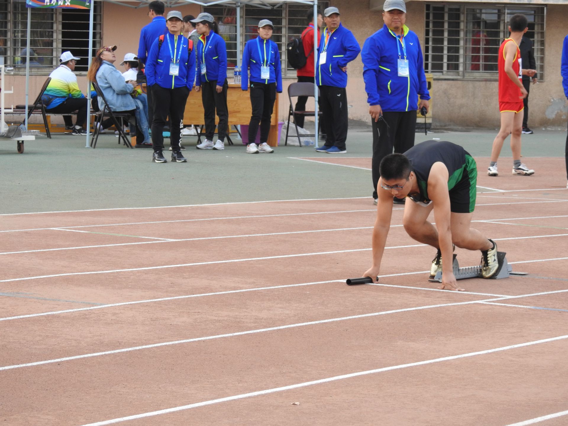 男子t60级4×100米接力决赛第一棒运动员李思伟在起跑线蓄势待发.